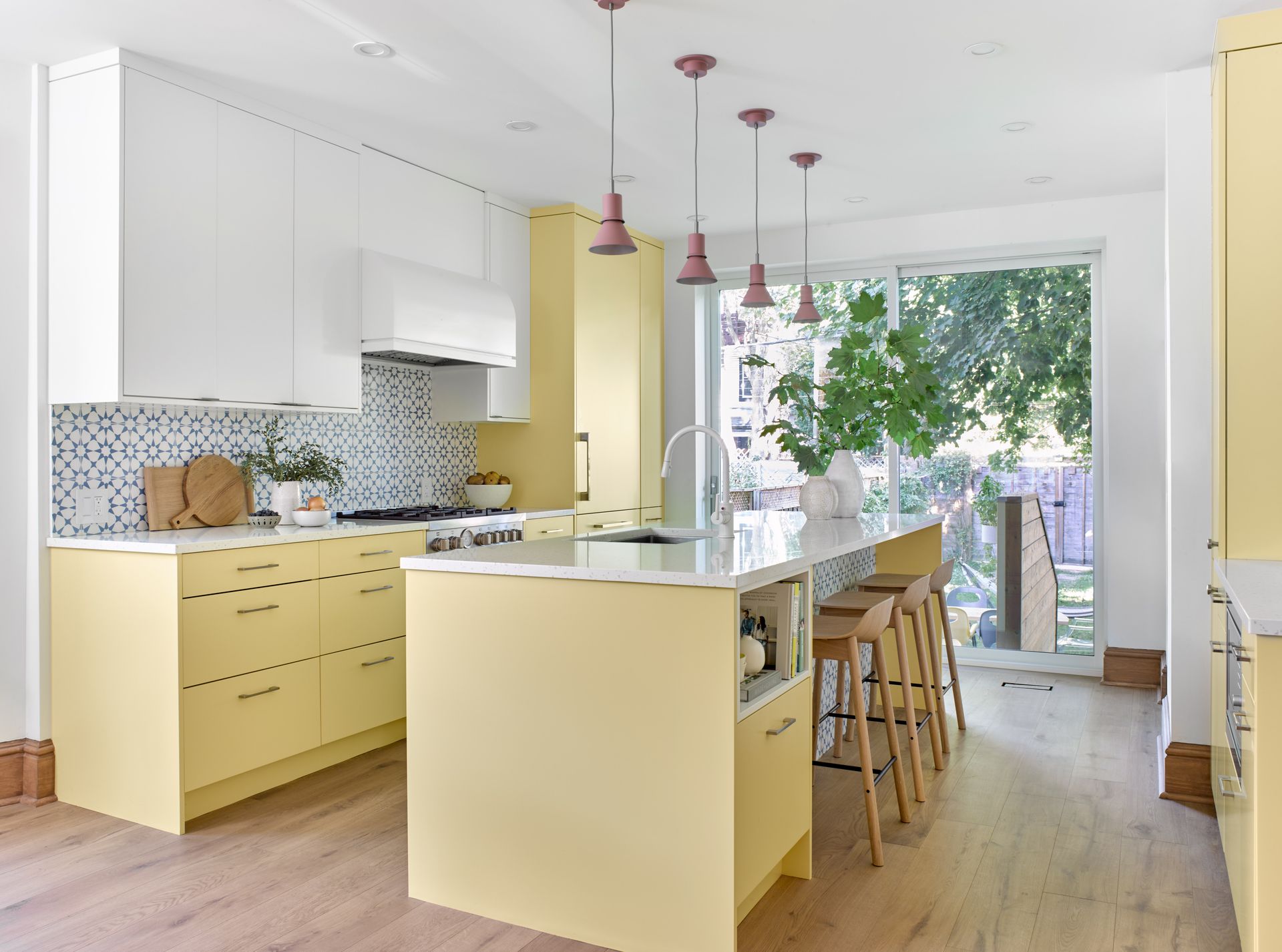 A kitchen with yellow cabinets and a large island.