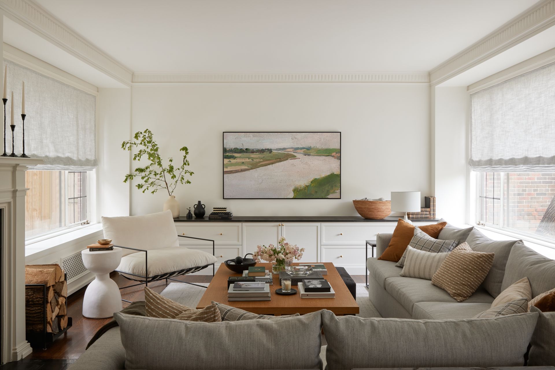 A living room with a fireplace , couch , coffee table and mirror.