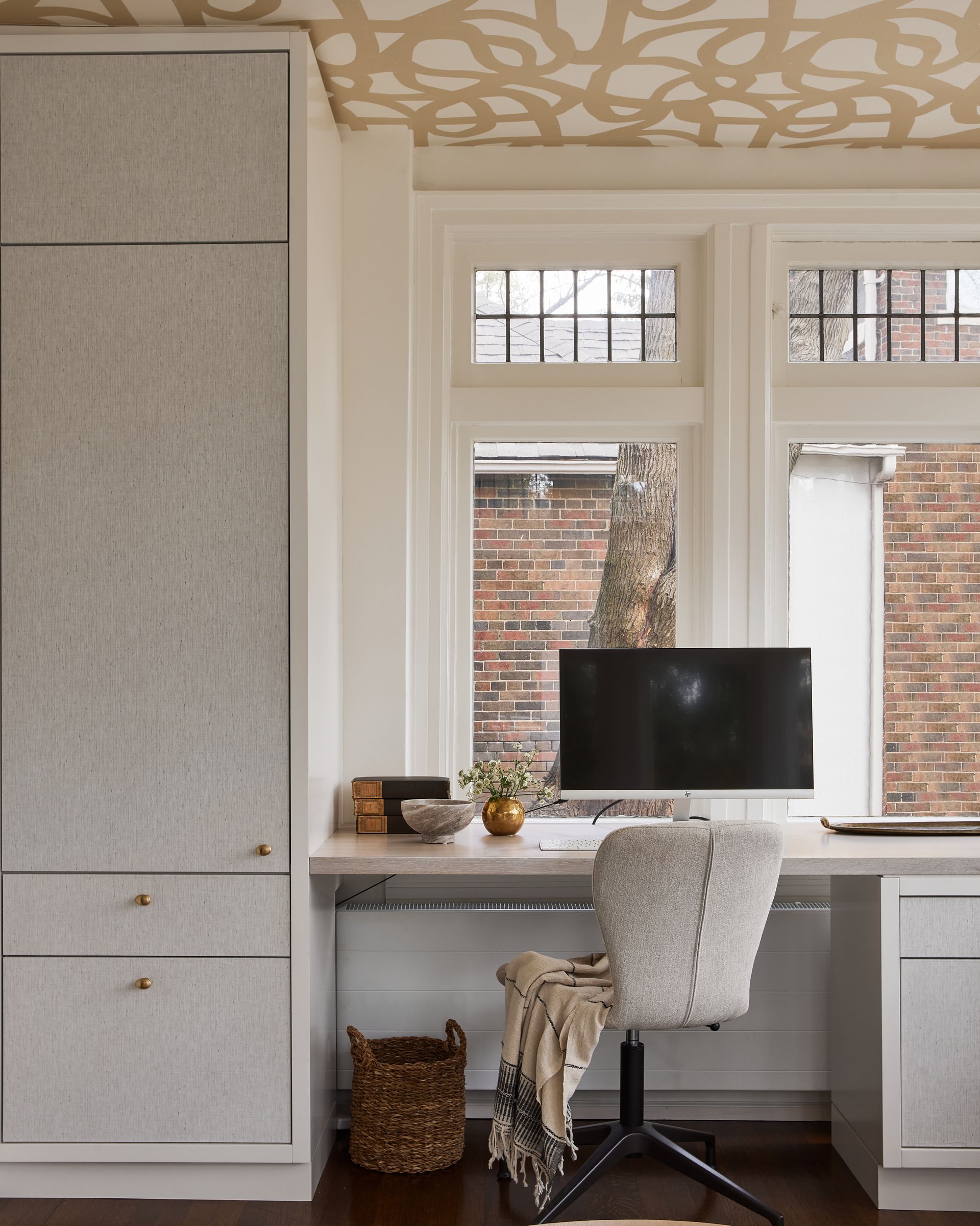 A desk with a computer and a chair in front of a window