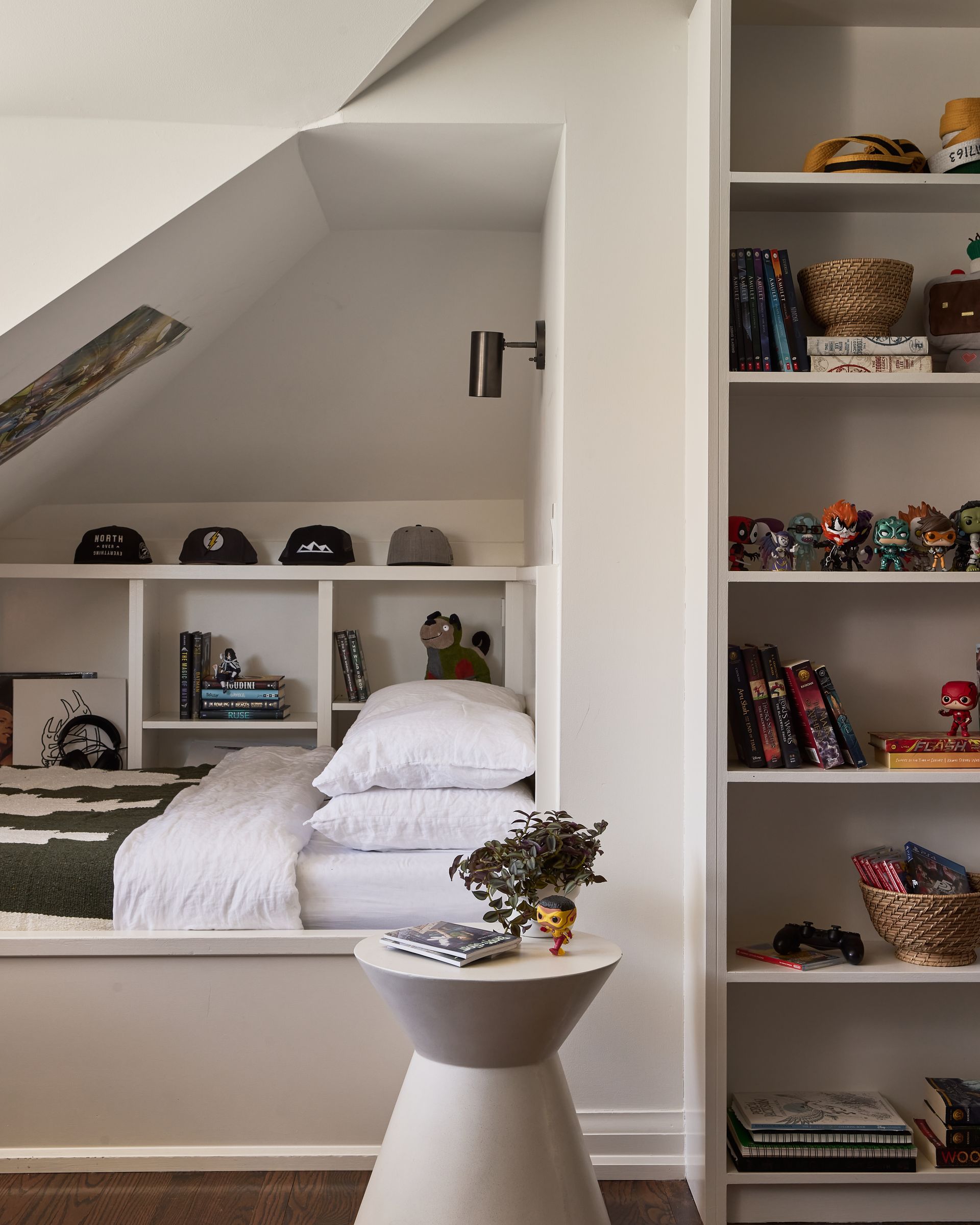 A bedroom with a bed and shelves with toys on them