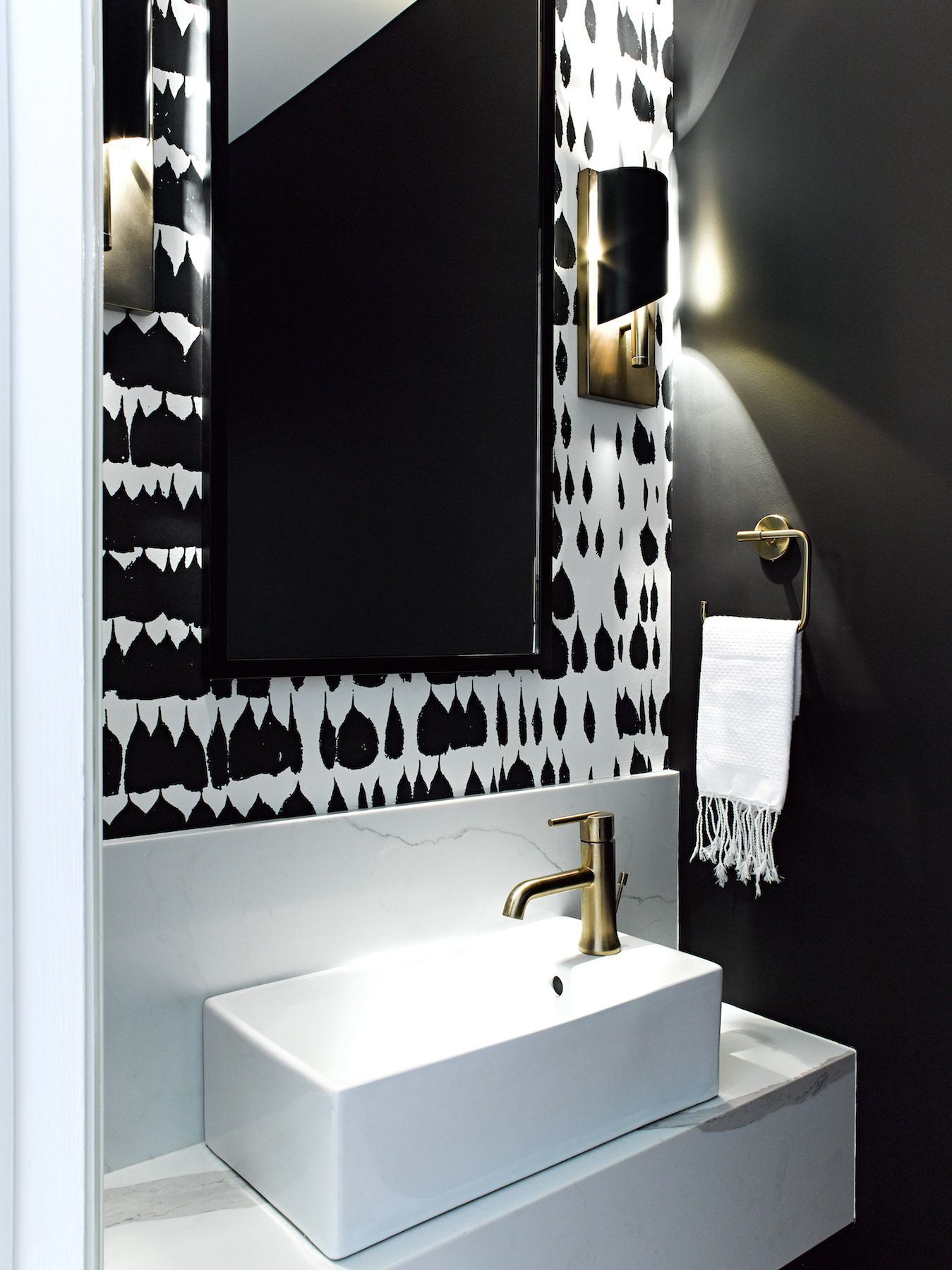 A bathroom with black and white wallpaper and a sink