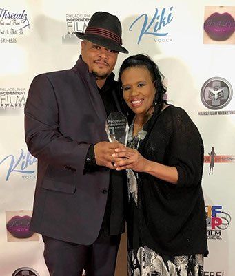 Jillian Bullock with a fellow award recipient, holding a crystal trophy at a film awards ceremony