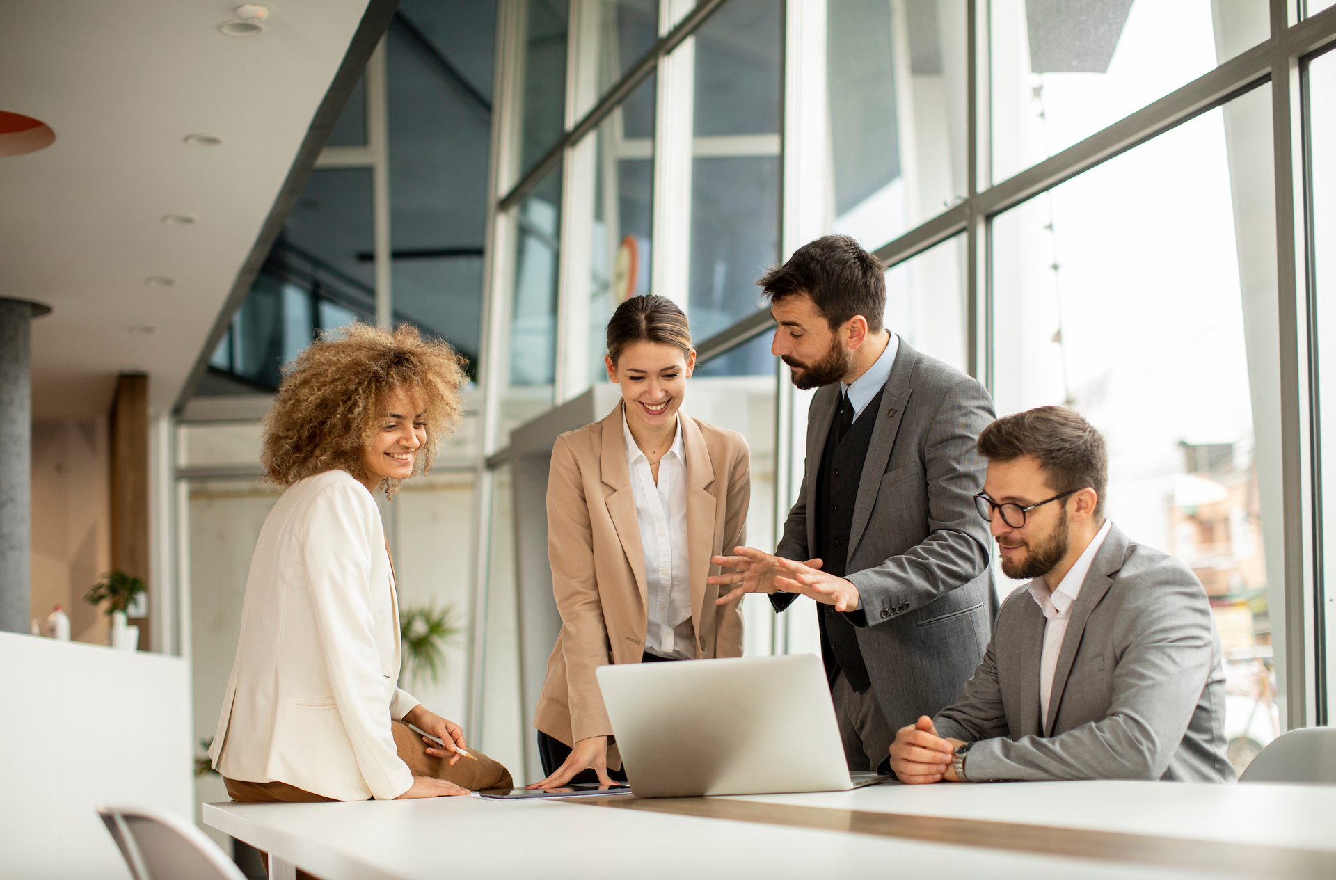 A group of business people are looking at a laptop computer.