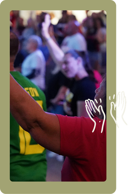 Crowd at a sports event with a player in a red jersey raising an arm in celebration