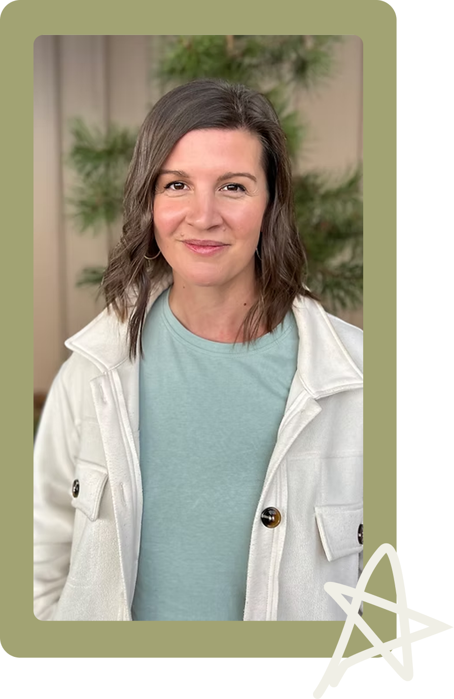 Portrait of a smiling woman in a white jacket and teal shirt against a blurred green background