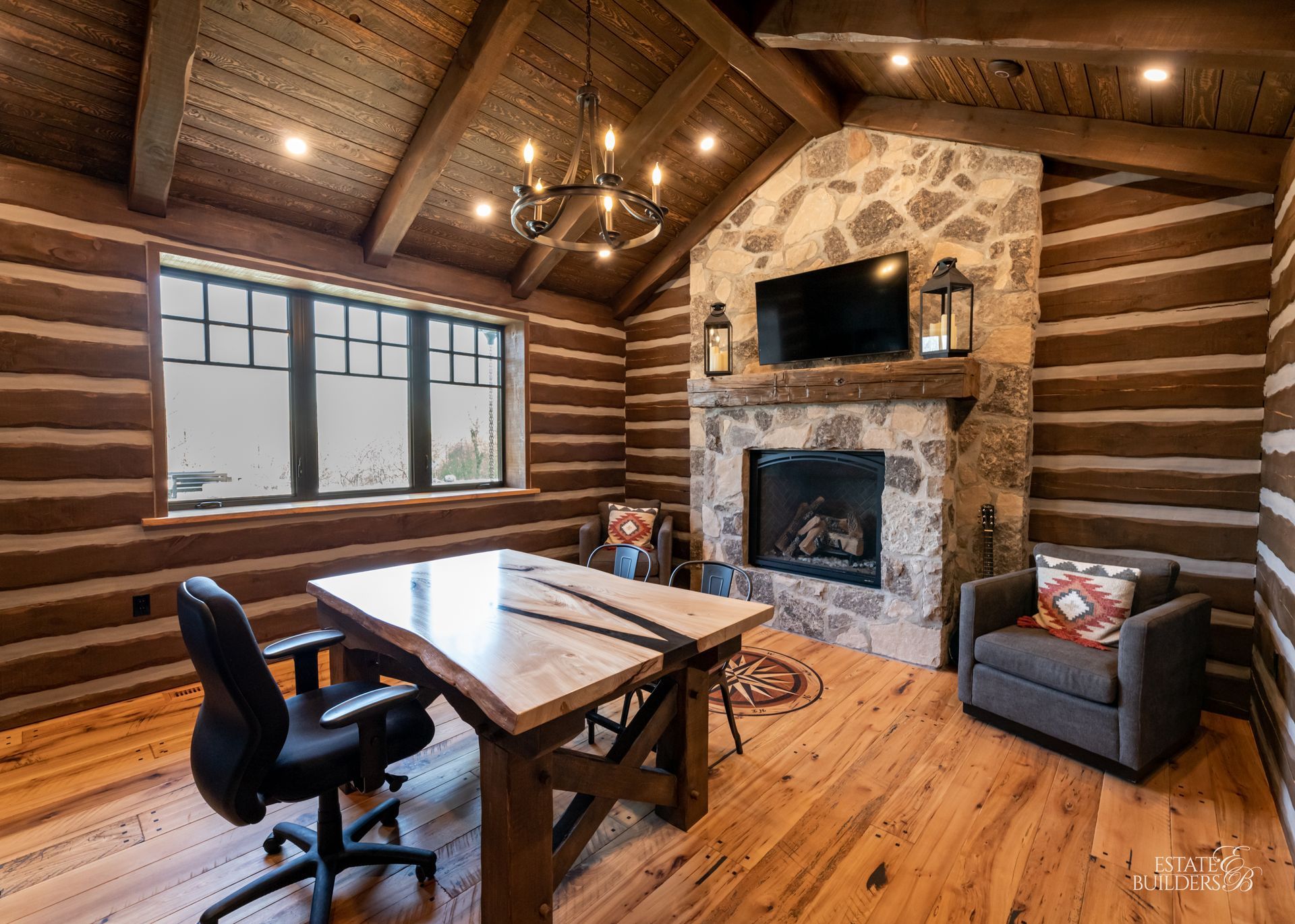 There is a fireplace in the middle of the timber framed room.