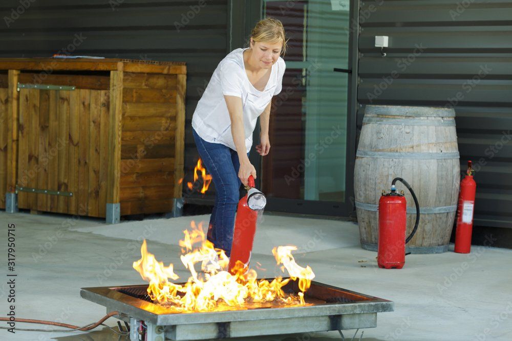 Frau löscht einen Brand, Feuerwehrübung