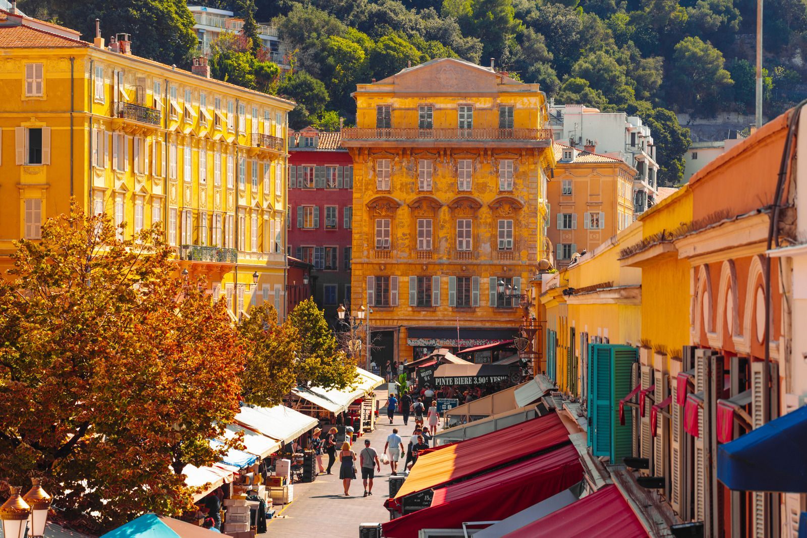 A city street with a lot of buildings and people walking down it.