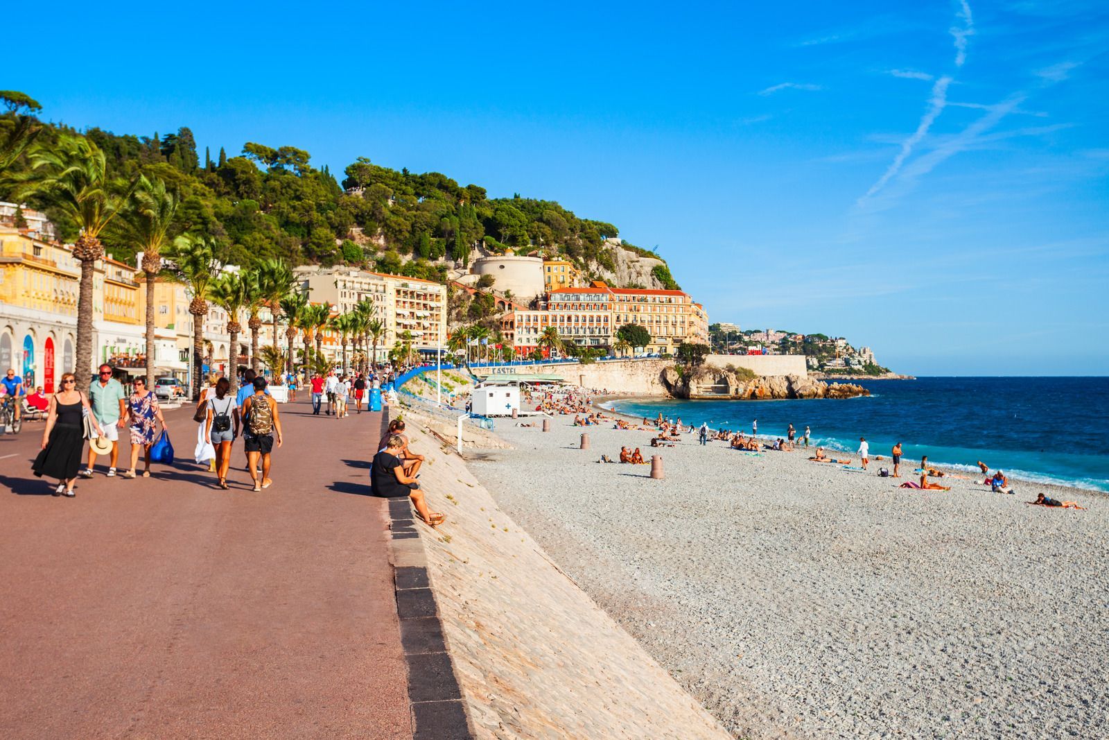 A group of people are walking along a beach.