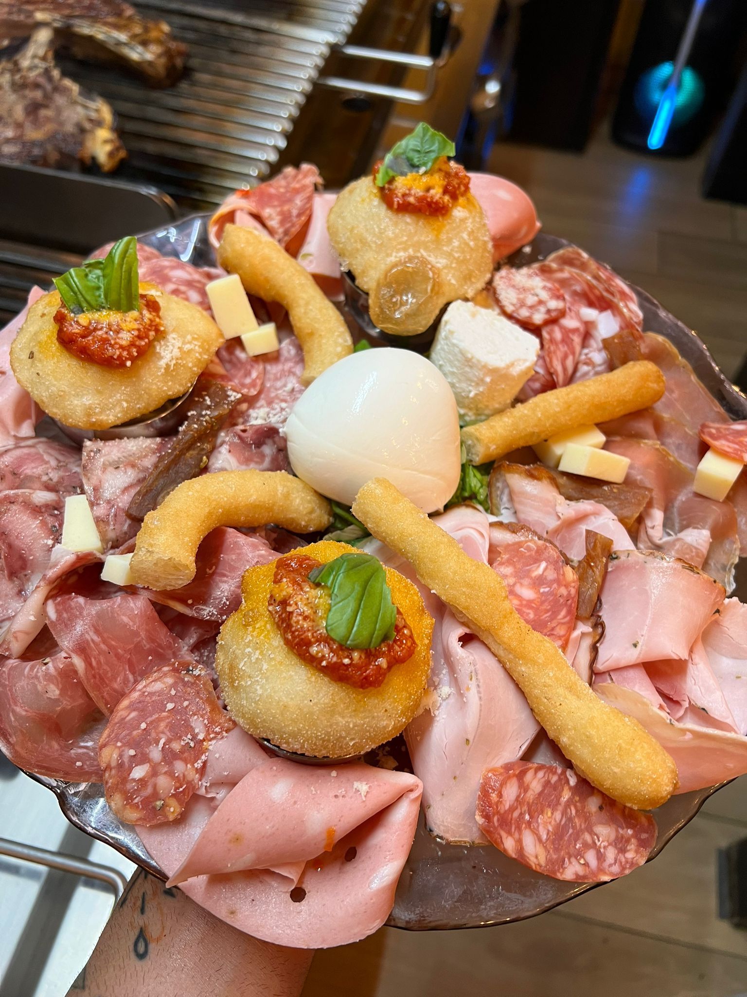 Piatto di salumi e formaggi con polpette fritte, grissini e mozzarella.