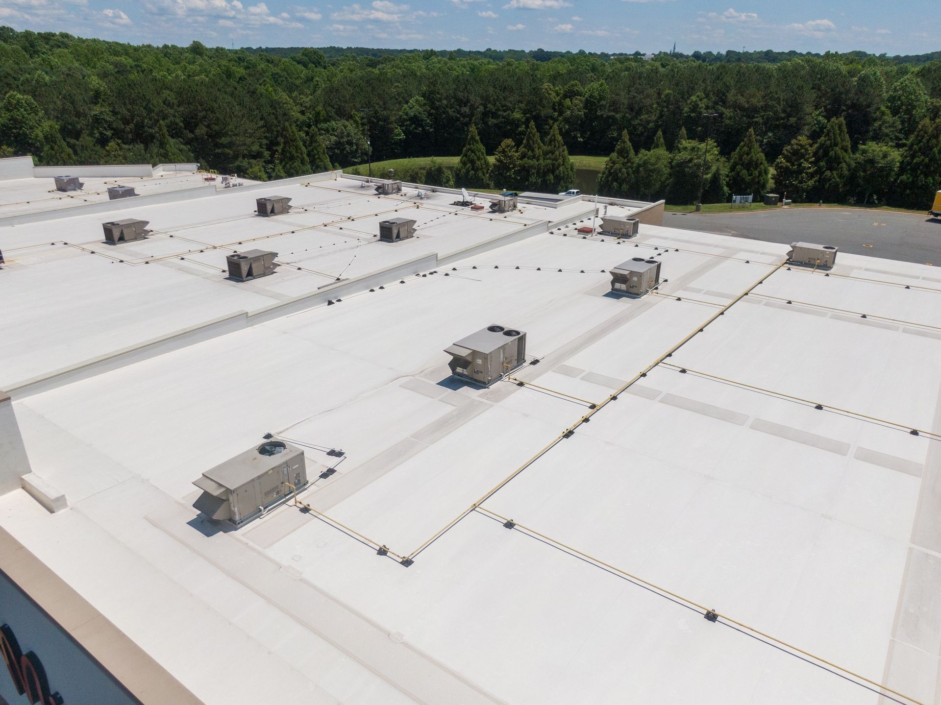 Overhead view of a metal roof with circular and linear patterns and several ventilation units.