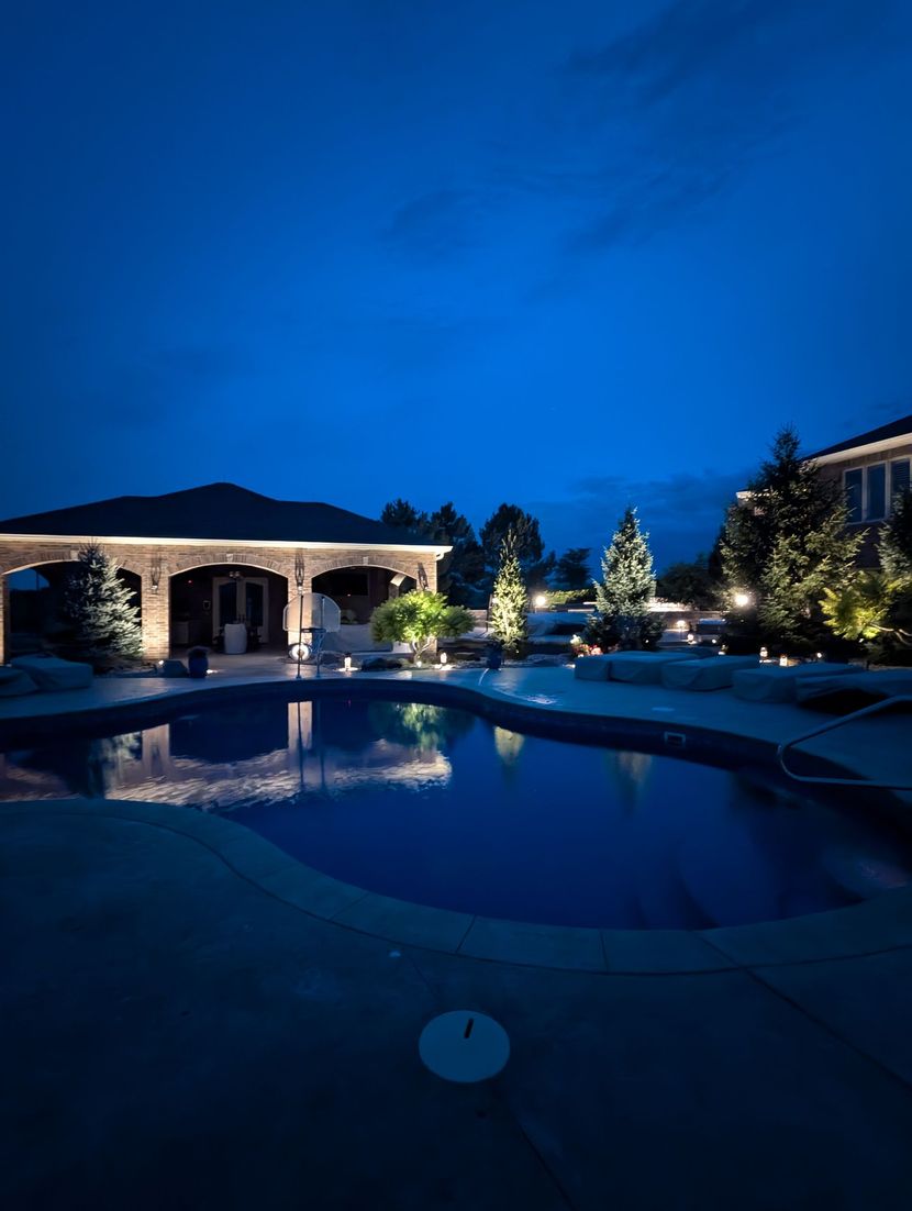 Luxury residential property with warm amber landscape uplighting at night