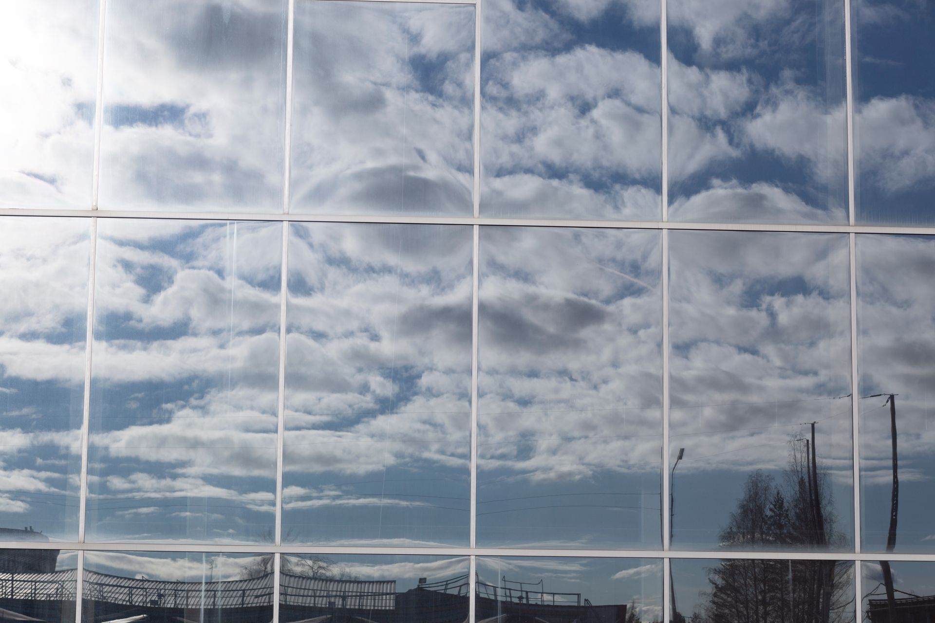 The clouds are reflected in the windows of a building.