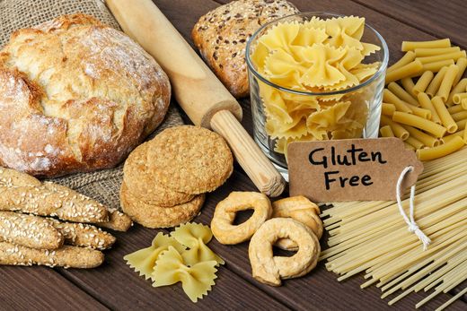 Pane, pasta e biscotti senza glutine disposti su un tavolo con un cartello 