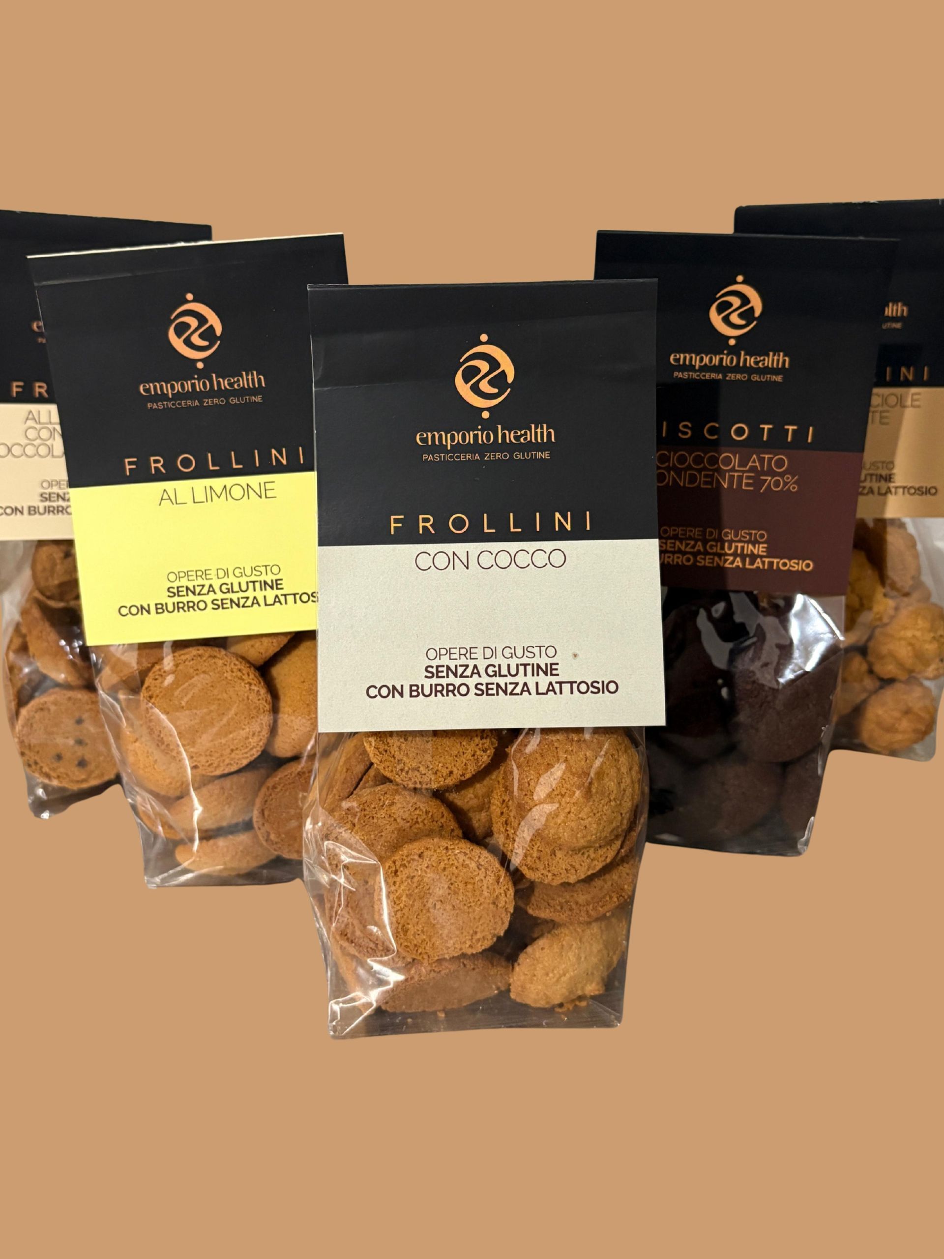 Tre sacchetti di snack simili a biscotti con etichette nere, gialle e bianche su sfondo beige.