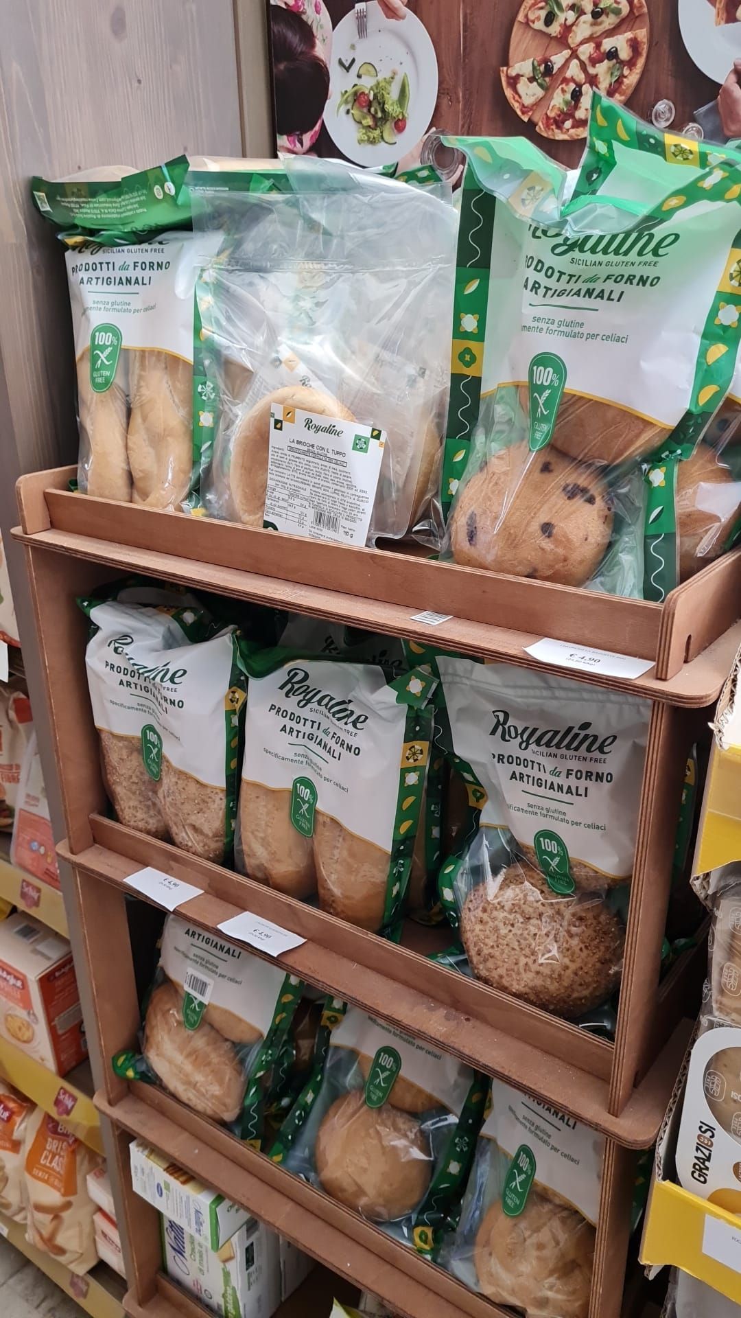 Esposizione di prodotti da forno confezionati assortiti in un espositore di cartone in un negozio.