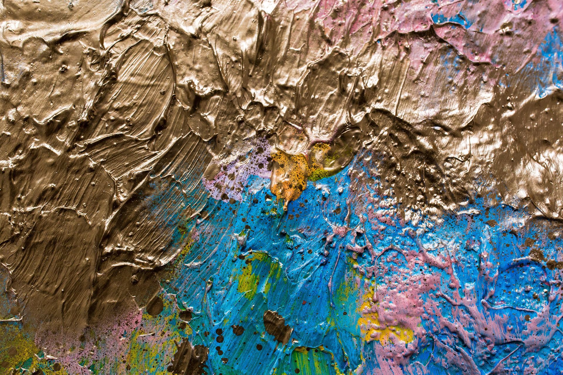 Textured abstract painting with gold, blue, pink, and yellow brushstrokes.