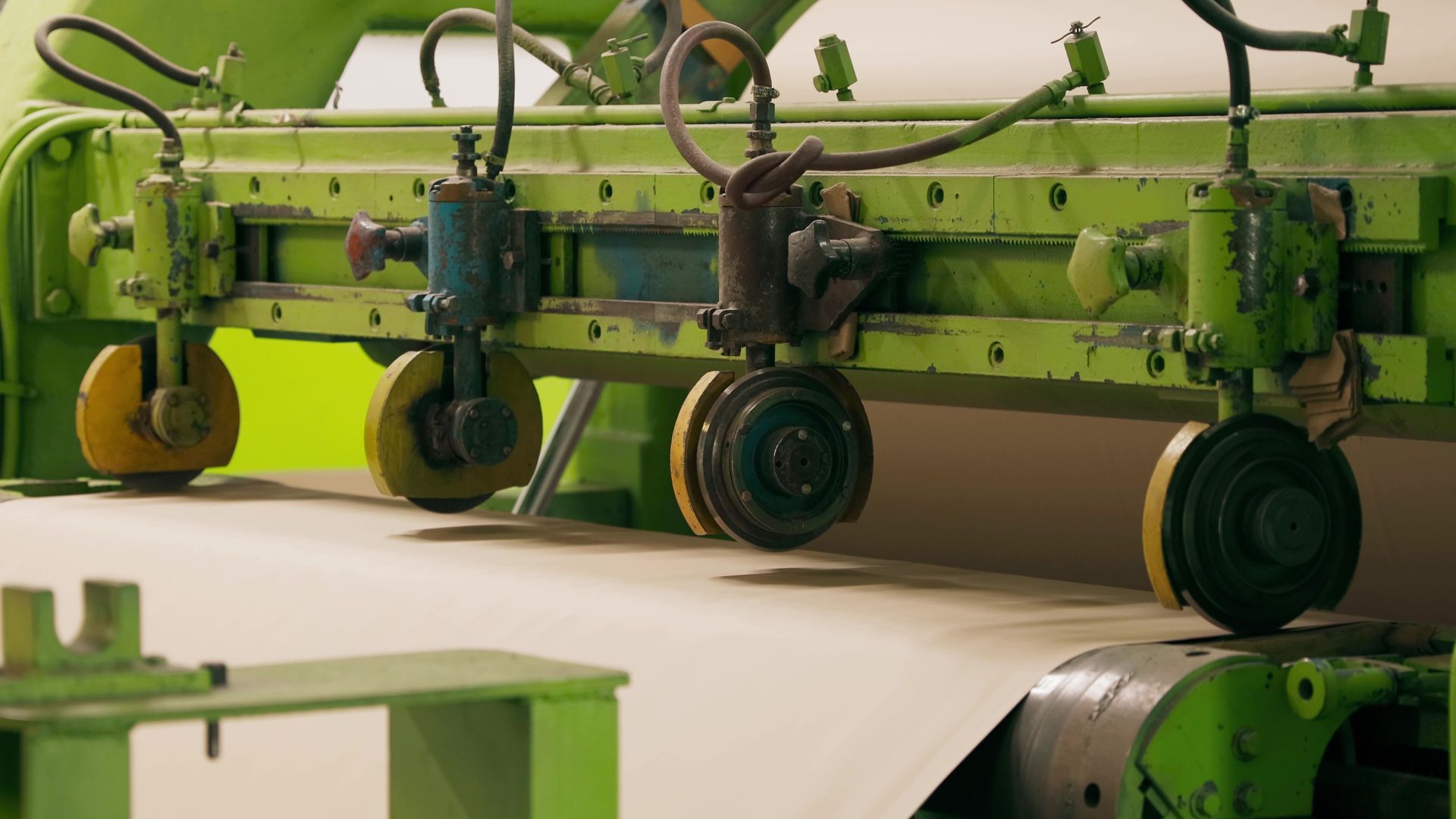Green industrial machine pressing paper.