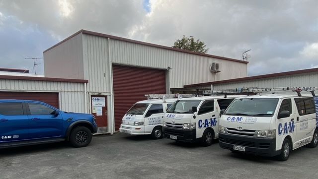 Vans and truck by warehouse.