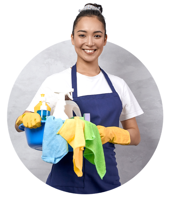 A smiling person in a blue apron and yellow gloves holding a blue basin with cleaning supplies and colorful cloths.