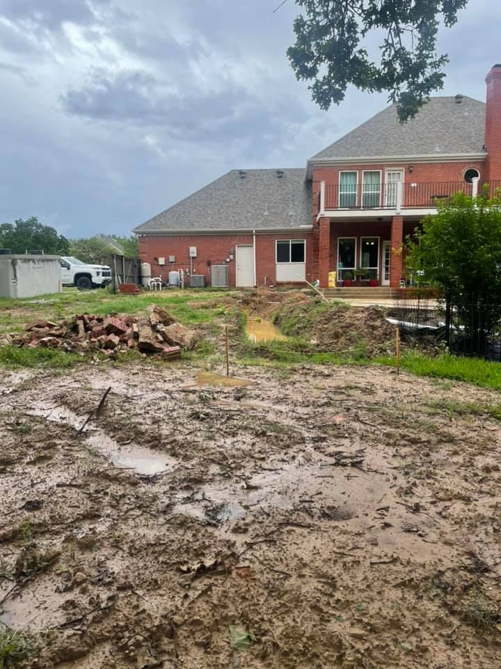 A large brick house with a lot of dirt in front of it.