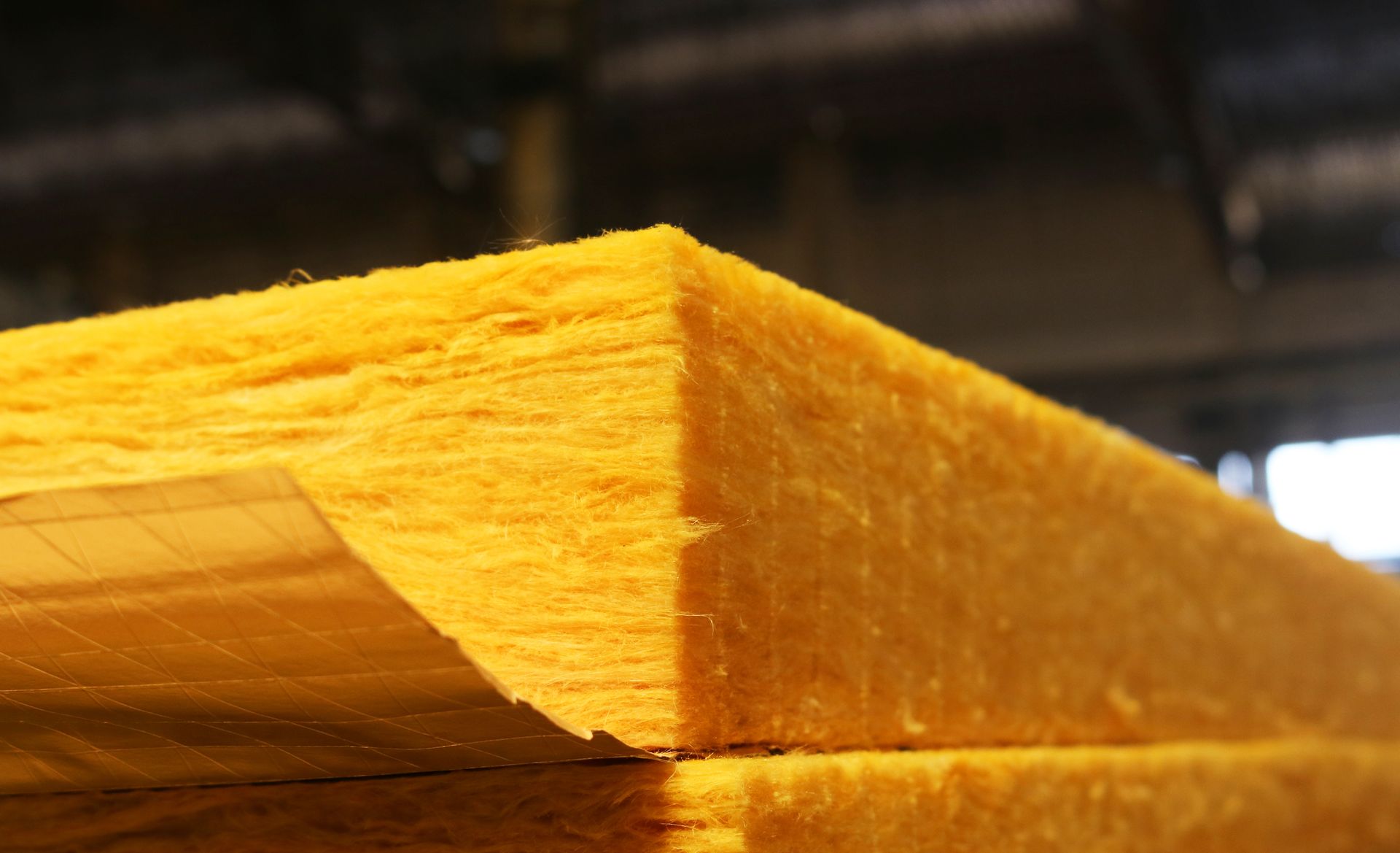 Close-up of stacked yellow wooden boards with rough, splintered edges