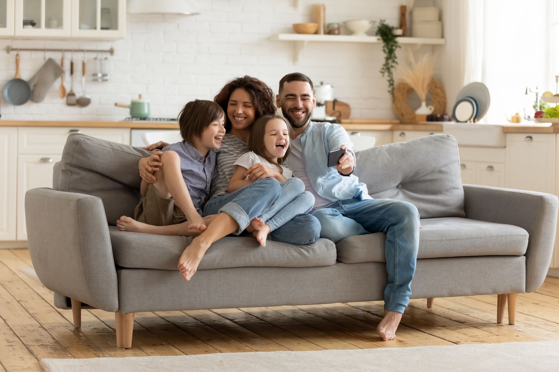 A family is sitting on a couch in a living room.