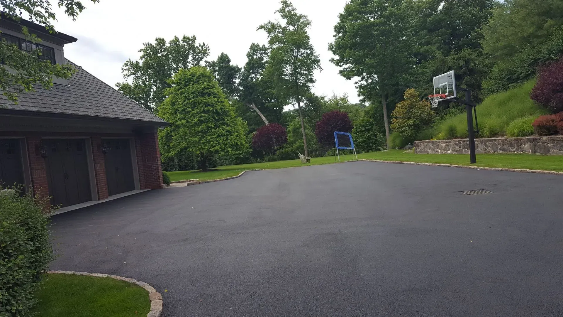 There is a basketball hoop in the middle of the driveway.