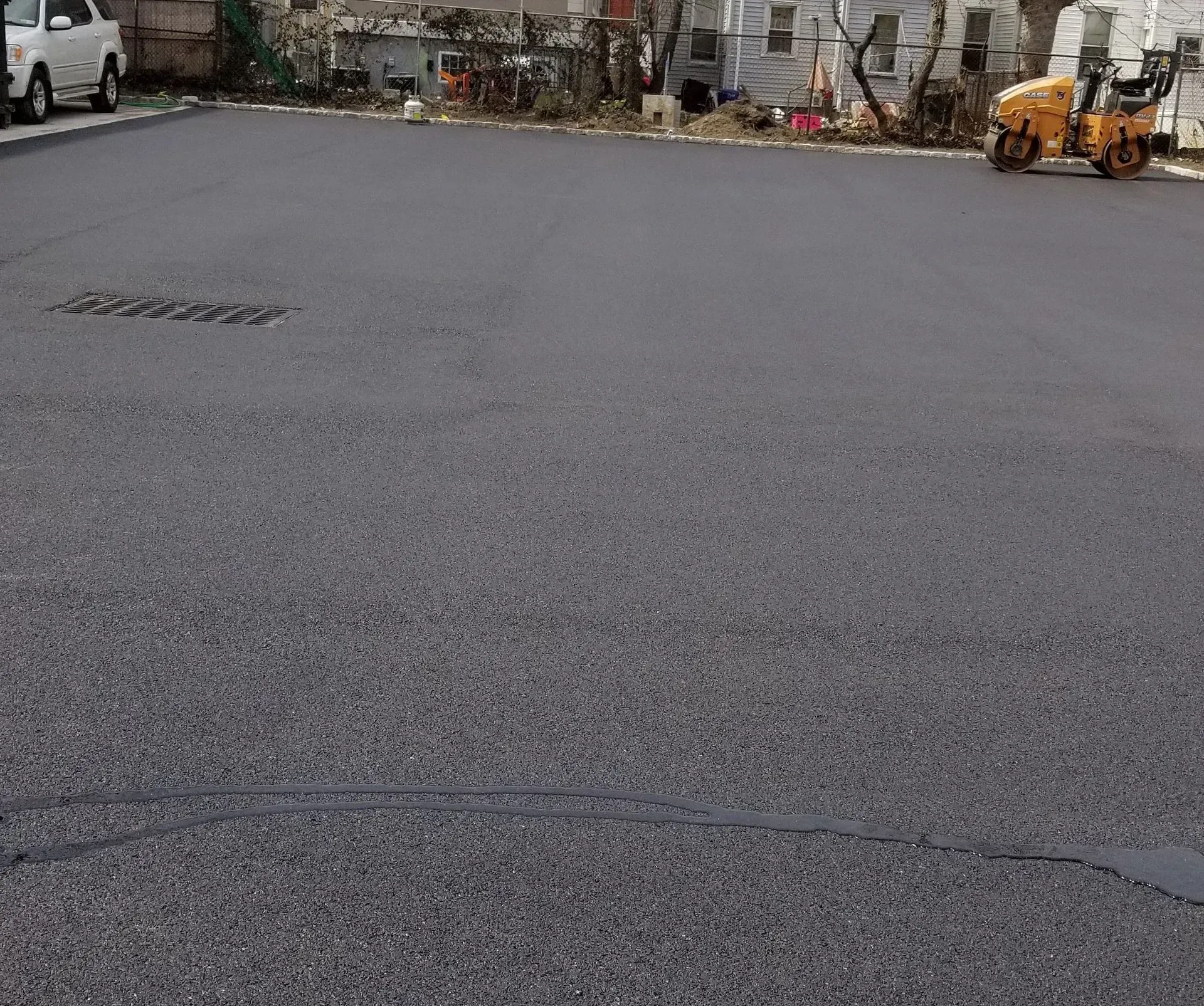 A yellow roller is rolling asphalt on a road.
