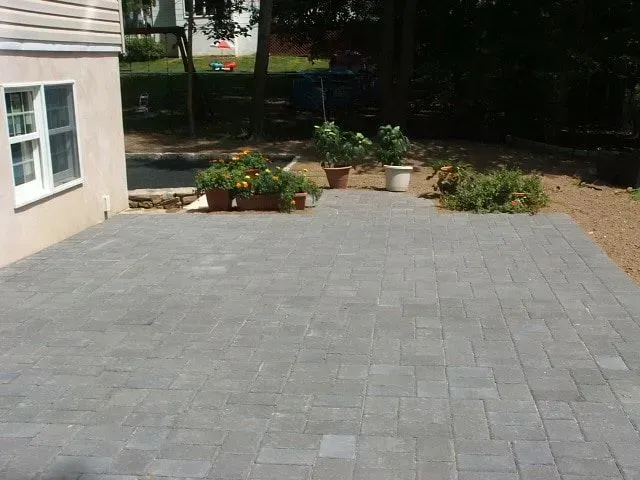 A patio with potted plants in front of a house.