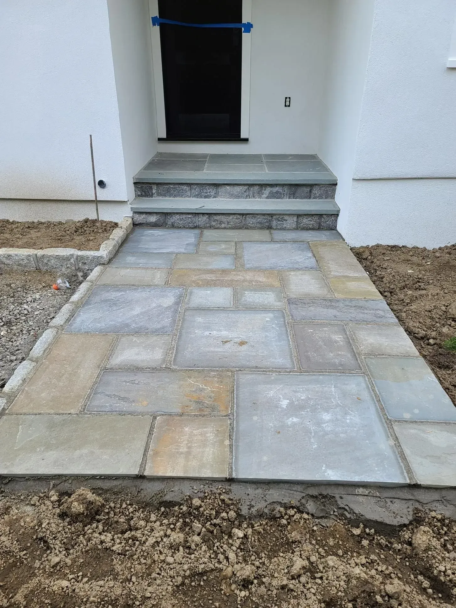 A stone walkway leading to the front door of a house.