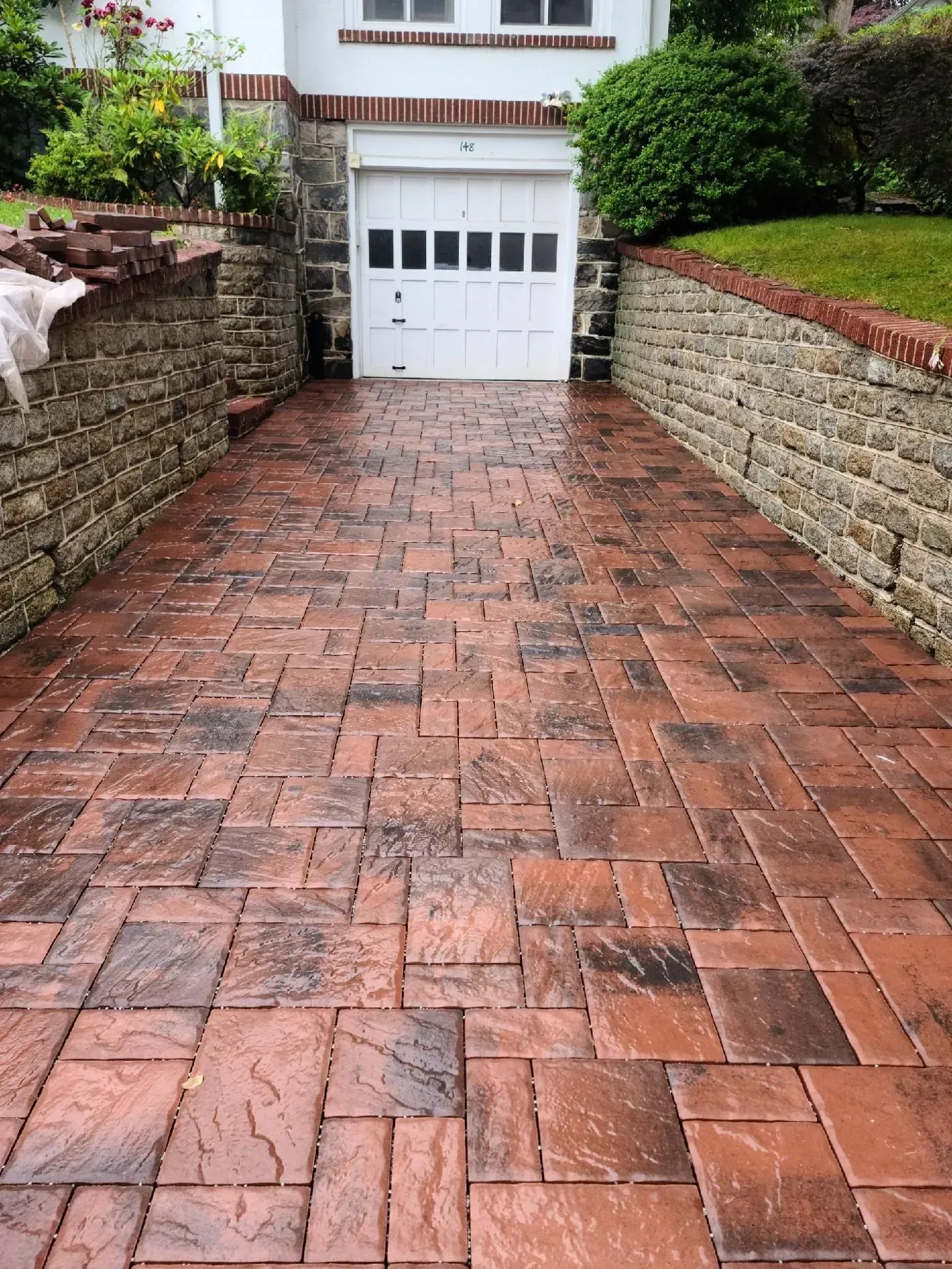 A brick driveway leading to a white garage door.