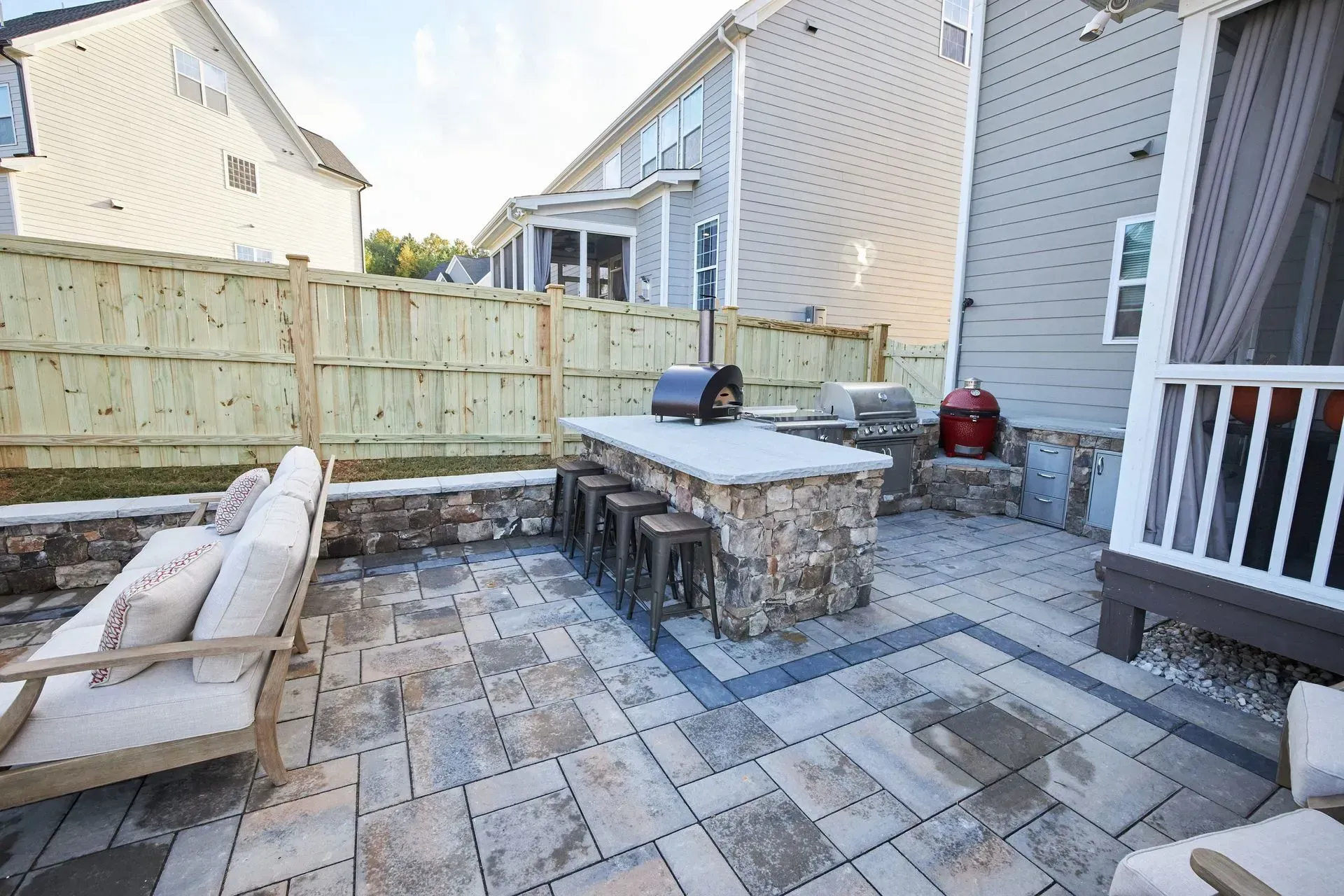 A patio with a table and chairs and a grill.
