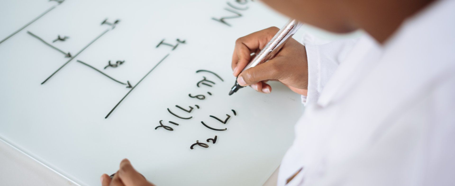 A person is writing on a whiteboard with a pen.