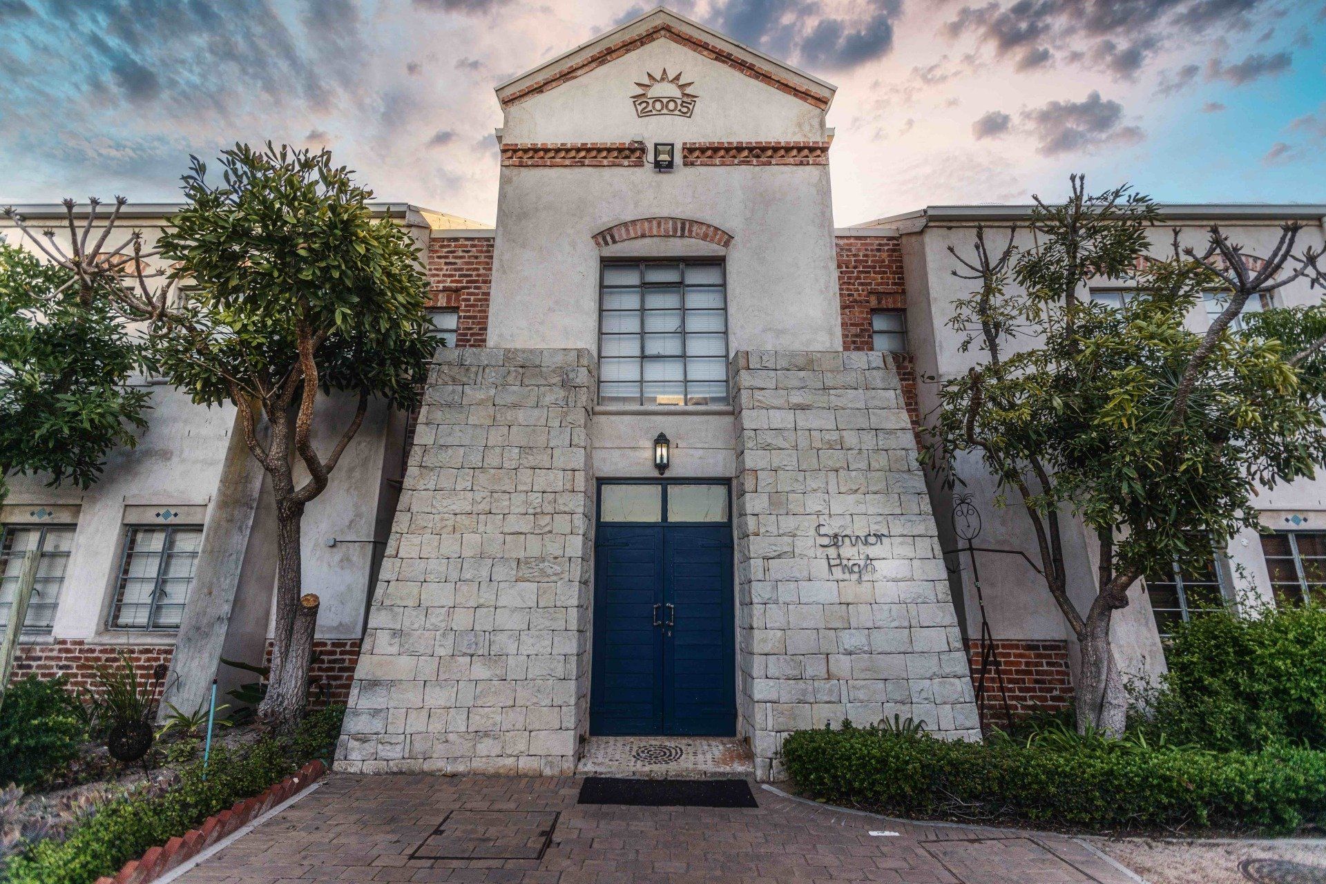 a white building with a blue door and stairs