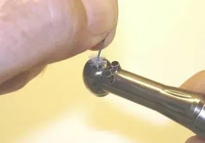 A person is holding a dental drill in their hand.