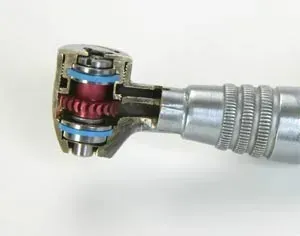 A close up of the inside of a dental drill on a white surface.