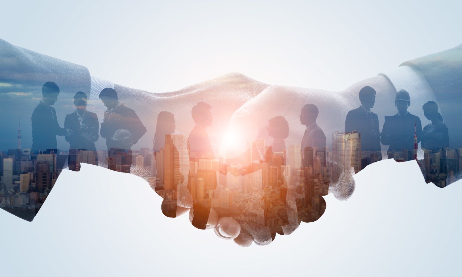 A group of people are shaking hands in front of a city skyline.