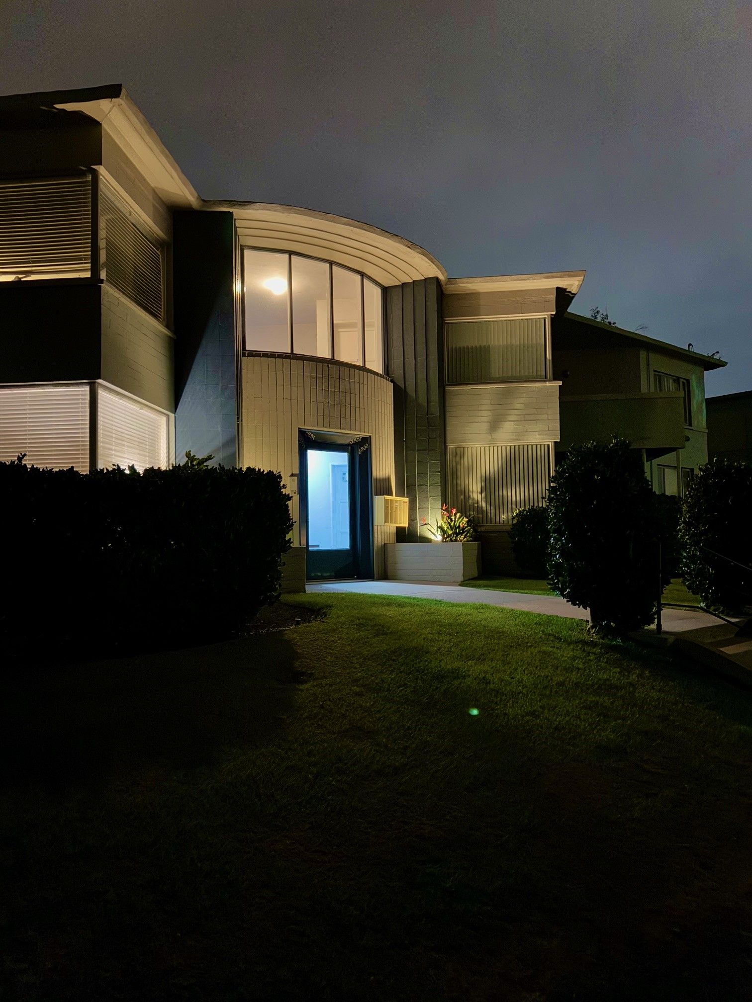 A house with a lot of windows is lit up at night