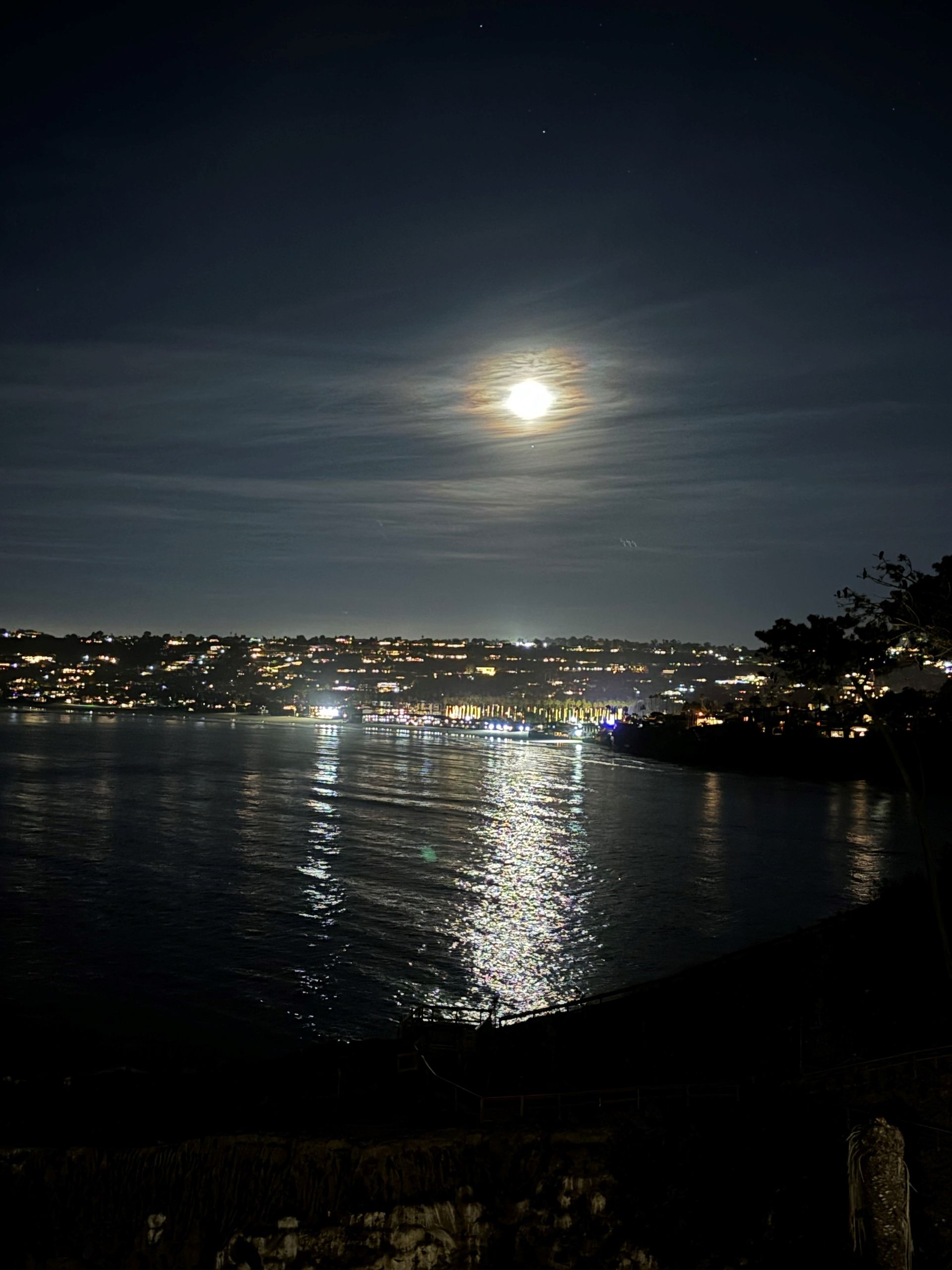 A full moon shines over a body of water