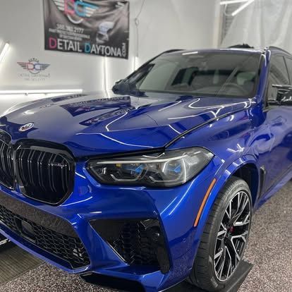 A blue bmw x5 m is parked in a garage.