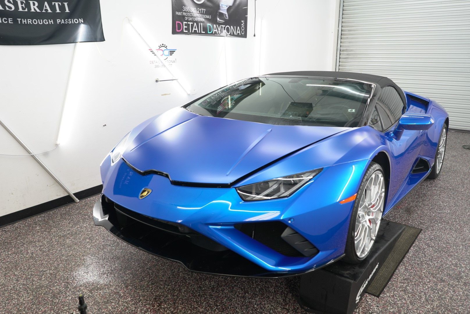Blue Lamborghini Huracan Spyder parked in a garage.