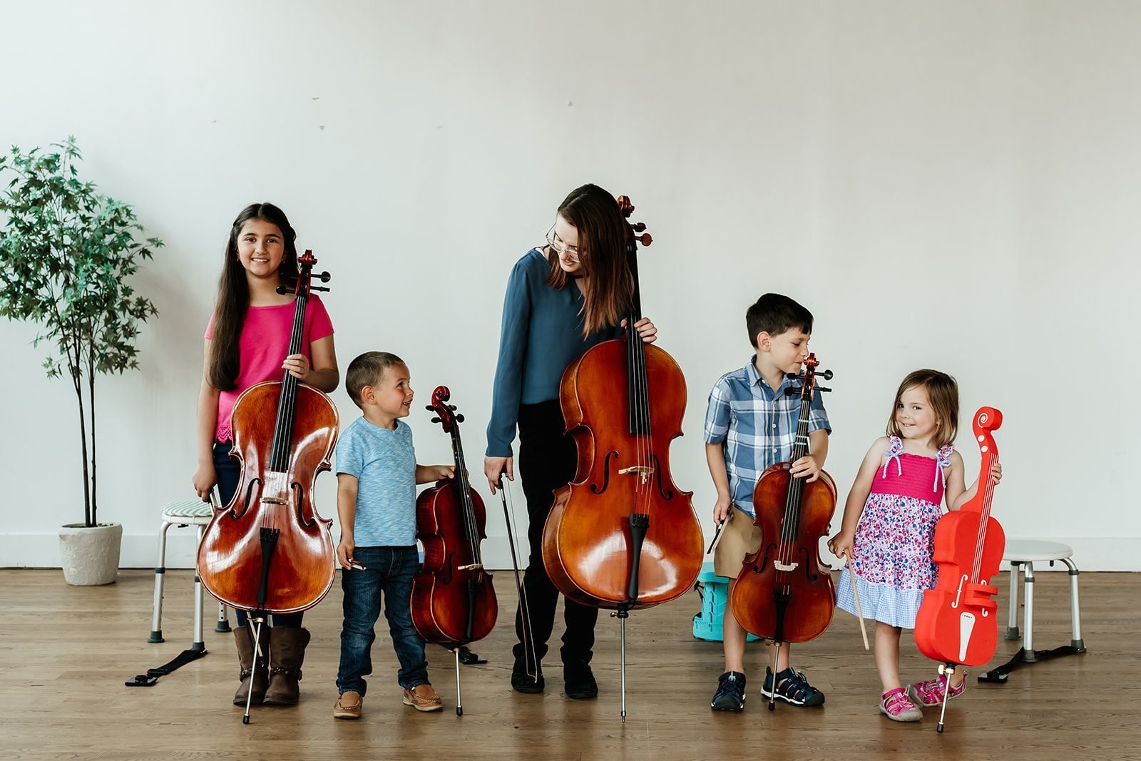 A group of children are standing in a circle holding violins.
