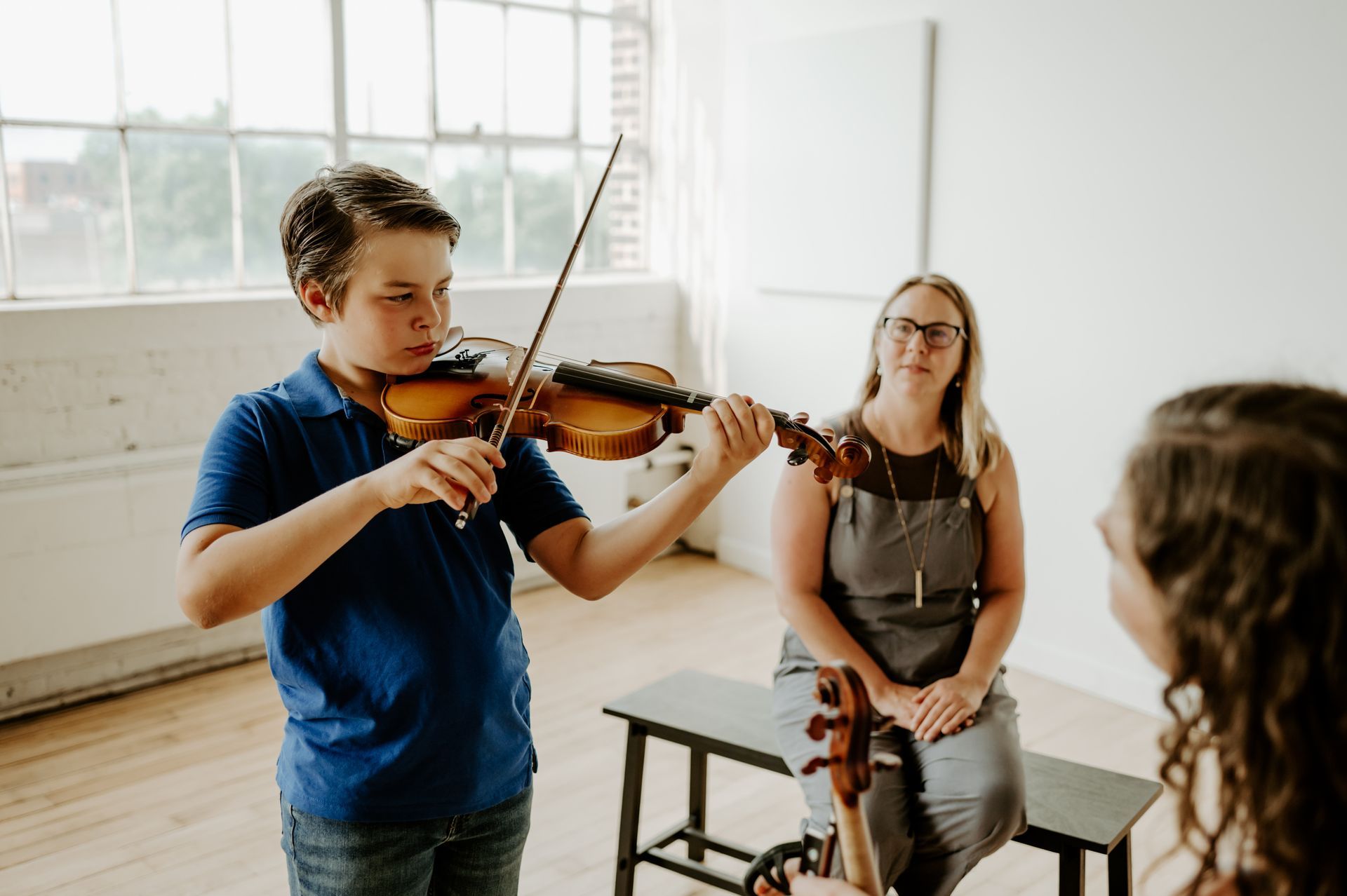 Homeschool violin lesson with student, teacher, and parent observing at Lakewood Suzuki Strings