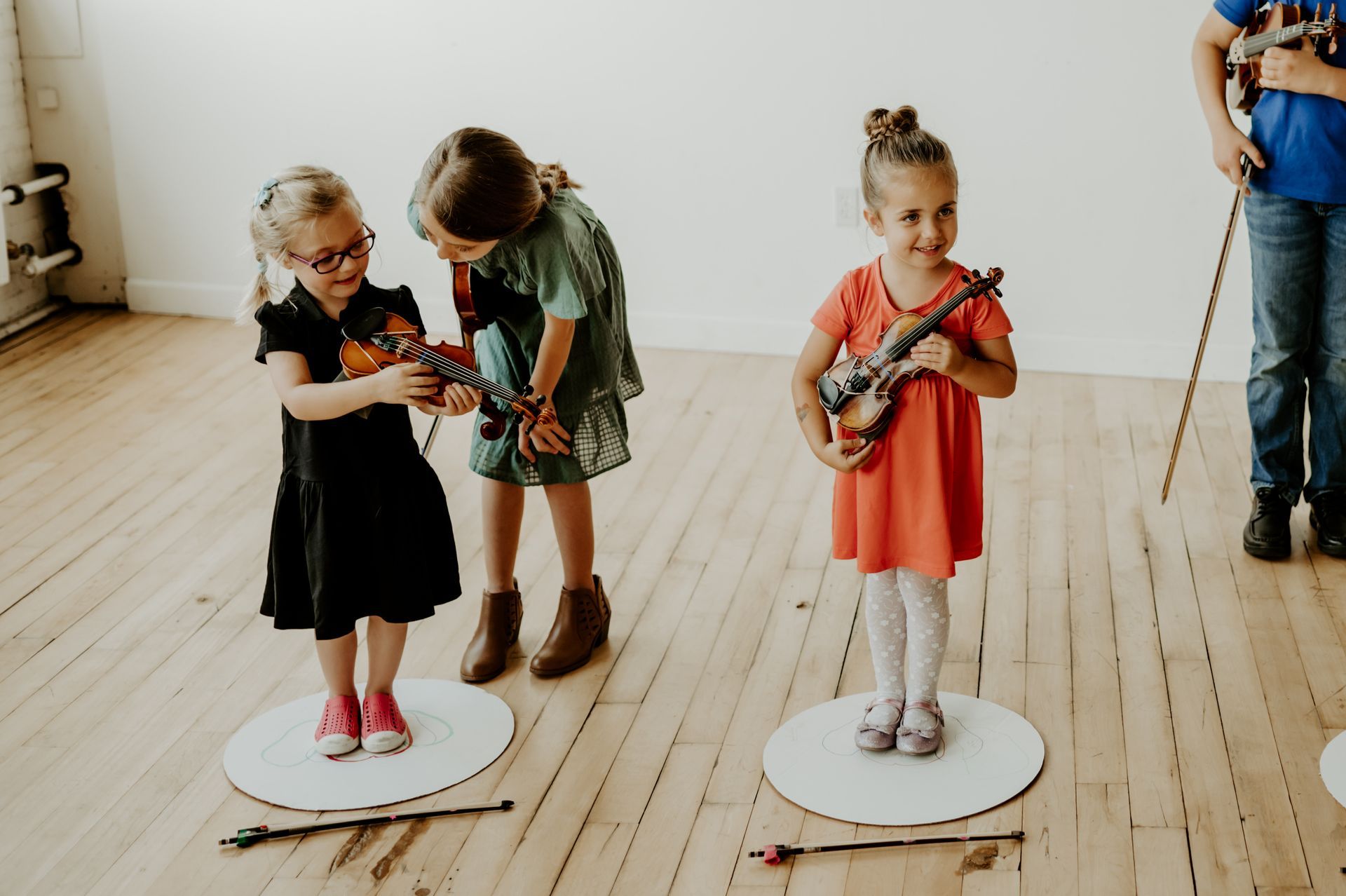 Three violin students participating in a group music class as part of the homeschool music program at Lakewood Suzuki Strings