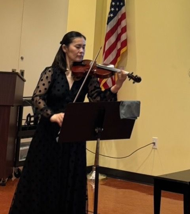 Yuko Nakamura is playing violin.