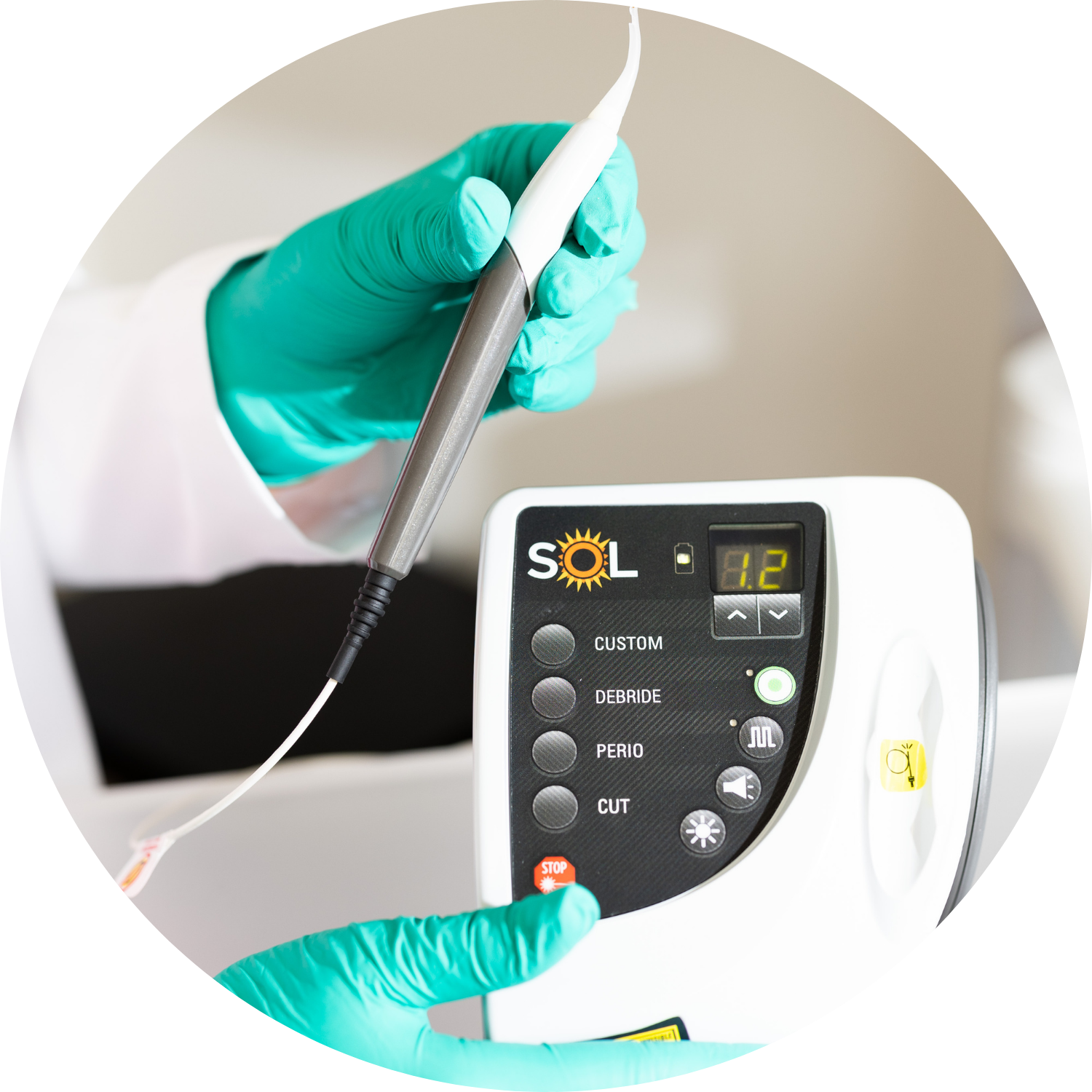 Person in gloves using a medical laser device. Hands operating the control panel and laser handpiece.