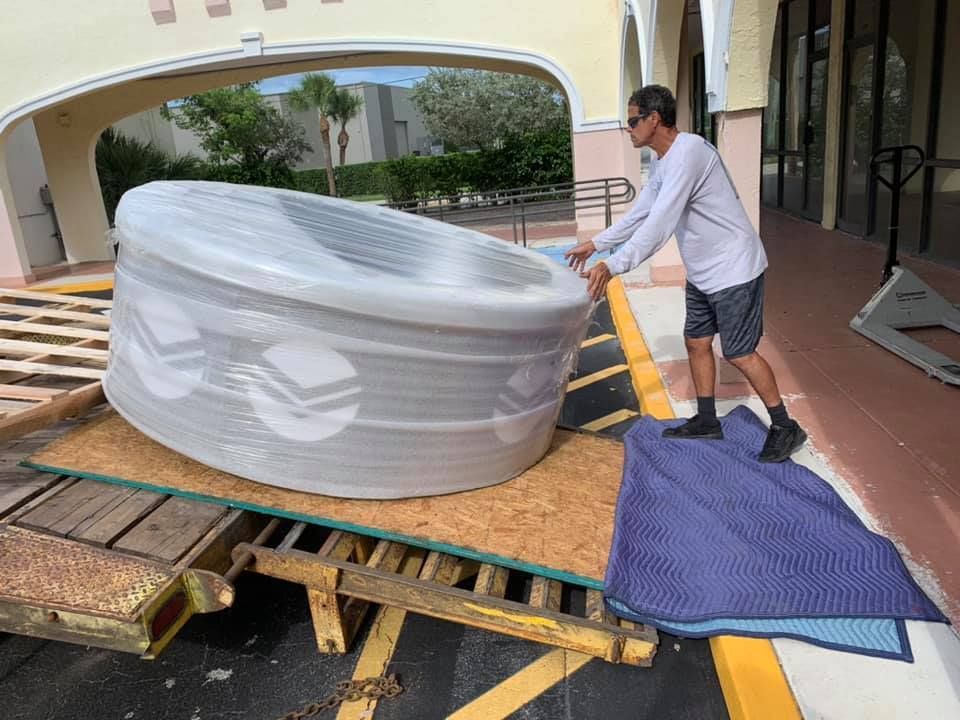 A man is pushing a large tub on a trailer. 28.4845° N, 81.2519° W