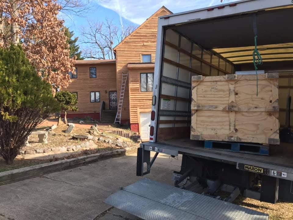 A truck is loaded with wooden crates in front of a house. 28.4845° N, 81.2519° W