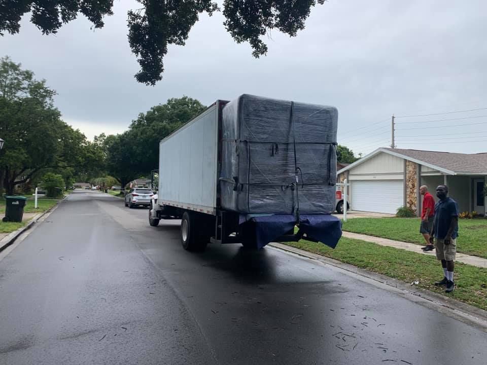 A white truck is driving down a street in a residential neighborhood. 28.4845° N, 81.2519° W